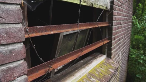 Camera moving closer to broken window with barbed wire Stock Footage 292528739