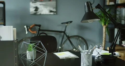 Camera moving up from the desk to the wall with picture of the cozy modern 스톡 동영상 104987672