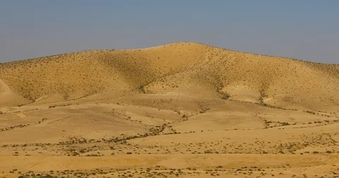 Camera moving down from hill to a small stones in desert Stock Footage 123953623