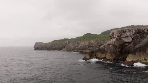 Camera moving forward above the ocean near cliffs Stock Footage 300624787
