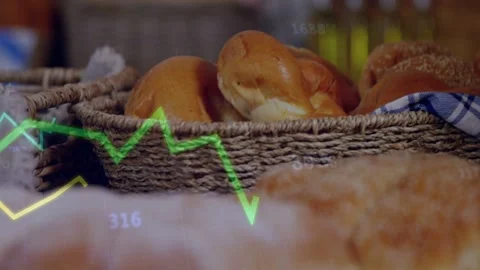 Camera moving forward, bread loaves coming into focus as green,yellow charts 스톡 동영상 332804388