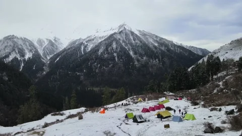 Camera moving forward to colorful camping tents. huge ice covered rocky mount Stock Footage 157664830