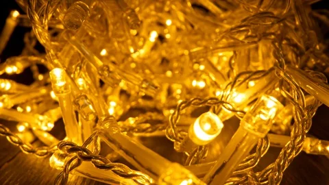 Camera moving forward inside of yellow Christmas garland that is lighting and Stock Footage 129796489