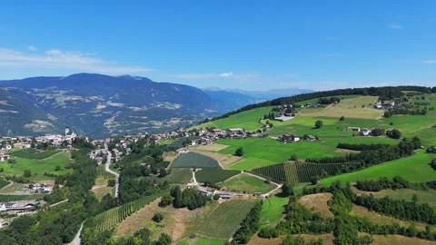 Camera moving forward over beautiful green valley with small village Stock Footage 285080743