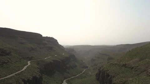 Camera moving forward revealing mountainous landscape with winding road Video stock 293158246