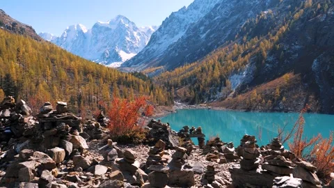 Camera moving forward showing turquoise lake with snowy mountains at autumn Stock Footage 290080894