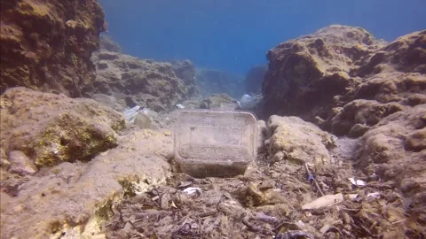 Camera moving forwards low along seafloor covered with lots of plastic debris in Stock Footage 255110362