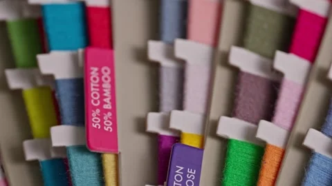 Camera moving over colorful sewing thread color palette samples Stock Footage 344512502