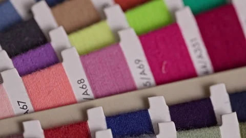 Camera moving over colorful sewing thread color palette samples Stock Footage 344512741