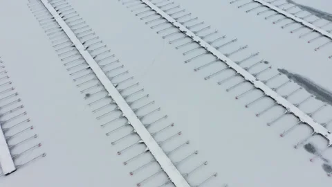 Camera moving over empty marina covered in snow, aerial view Stock Footage 289005101