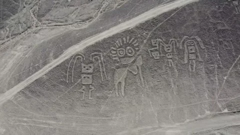 Camera moving over group of human figures of the Nazca Lines geoglyphs made  Stock Footage 251933480