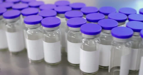 Camera moving over medical vials with purple caps Stock Footage 293095121