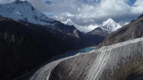 Camera moving over rock landslide revealing Laguna Paron and snowcapped moun Stock Footage 252372745