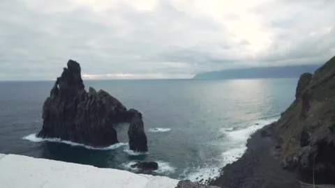 Camera moving right revealing volcanic sea stack Stock Footage 293159479