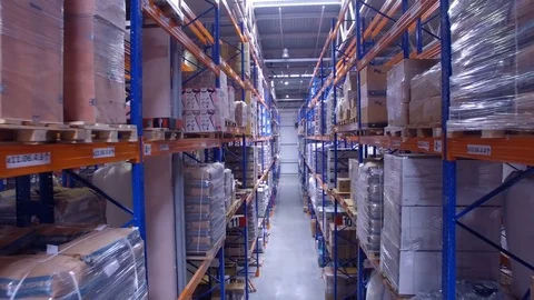 Camera moving straight between warehouse racking rows. Stock Footage 82857667