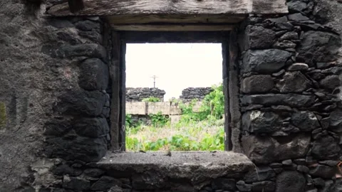 Camera moving through ancient stone window revealing ruined building Video stock 293159218
