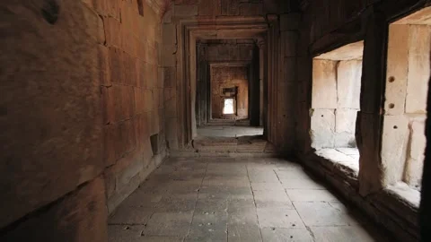 Camera moving through a long, ancient stone corridor inside a cambodian temple 스톡 동영상 323077996