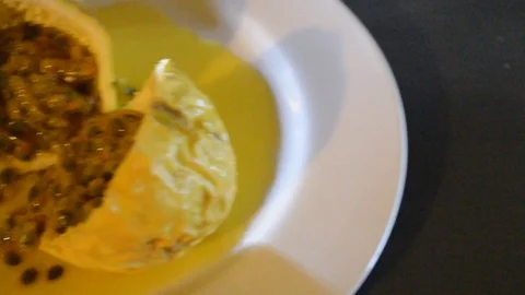 Camera moving through scene for passion fruit in half on a white plate Stock Footage 115373100