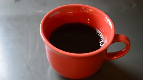 Camera moving through scene until a red cup full of black coffee - vertical 스톡 동영상 114994711