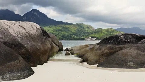 Camera moving towards the ocean between big rocks Stock Footage 132544912