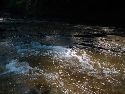 Camera moving upstream over cascading waterfalls stabilized Video stock 77164559