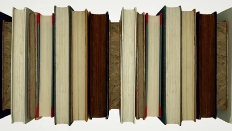 The camera observes a row of old books moving from left to right with their Stock Footage 155179239
