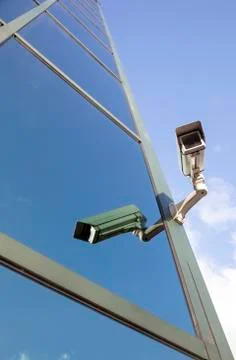 Camera on office building reflecting clouds and sky Stock Photos