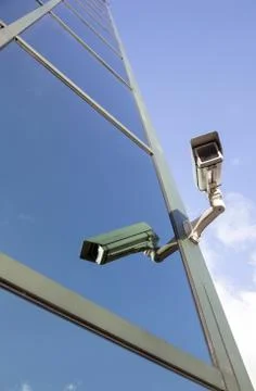Camera on office building reflecting clouds and sky Stock Photos