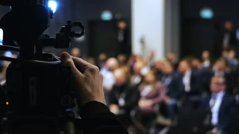 Camera operator filming audience at business conference event. Vídeo Stock 347779230