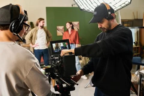 Camera Operator Filming Scene with Actors in Studio Setting Stock Photos