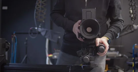 Camera operator moves Mamiya medium format camera on studio slider. 库存影片 313980959