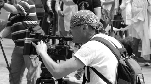 A camera operator, photographer sets up the technique before shooting video. Stock Footage 133486038