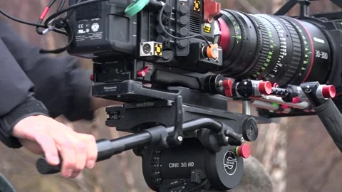 Camera Operator Swivels Large Cinema Camera on Tripod Stock Footage 230168415