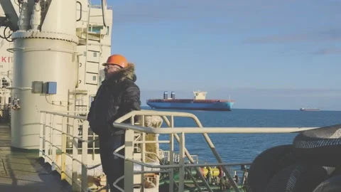 Camera operator walks along tanker against container ship Stock Footage 133036937