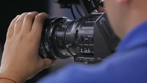 Camera operator working with a cinema broadcast TV camera. Back view Stock Footage 94374609