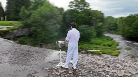 Camera Orbit Around Pianist Playing Digital Piano With Waterfall View Video stock 341830105