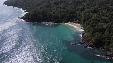 The camera orbits overhead, showcasing a pristine beach nestled between a Vidéo 282883572