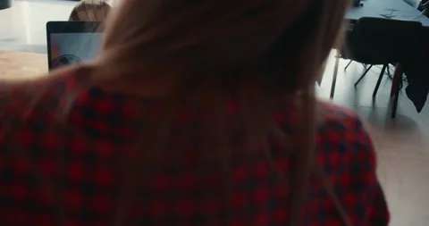 Camera over shoulder on young freelance business woman talking to friend using Stock Footage 148331216