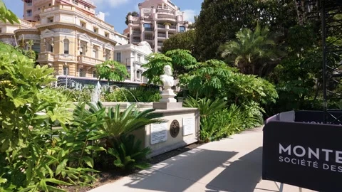Camera pan left from Monte Carlo brand barrier to fountain and bust monument Stock Footage 337513820