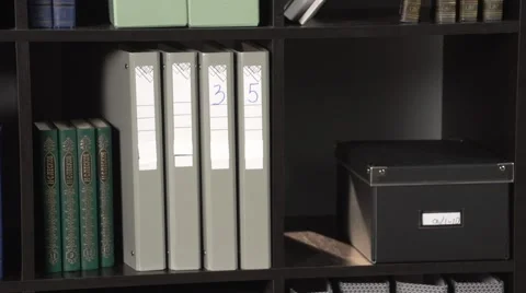 Camera pan in office cupboard from right to left. Files in cupboard. Stock Footage 60814096