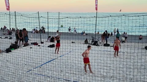 Camera pan right of crowded beach volleyball courts 스톡 동영상 336923105