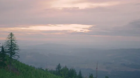 Camera pan of Sunset with Mountains, hills and trees below Stock Footage 144208276
