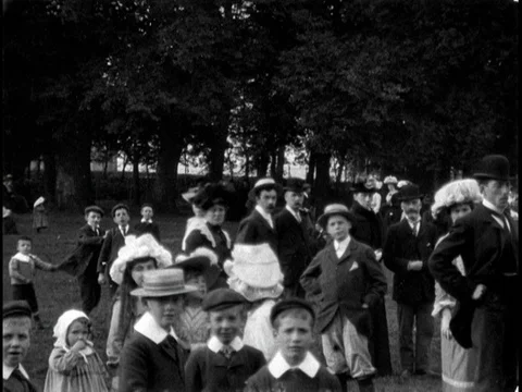 Camera pan through Abington Park with teaming crowd of adults and children, 1902 Video stock 136683677