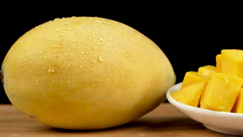 Camera Pan from Whole Ripe Yellow Mango to Diced Fruit Plate Vidéo 335257044