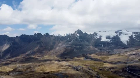 Camera panning across the face of a snowcapped mountain peak high up in the Ande Stock Footage 251761844