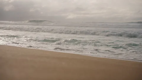 Camera Panning Across Sandy Beach Splashing Waves Stormy CLouds 4K Stock Footage 267048412