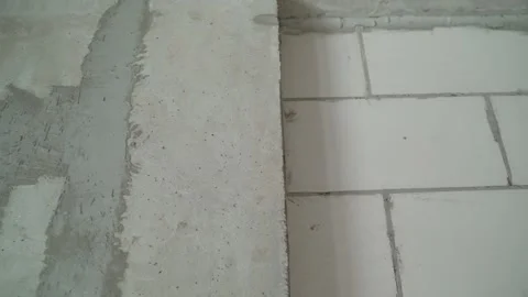 Camera panning across unfinished wall with aerated concrete blocks and plaster Stock Footage 345537274