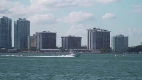 Camera panning and following a boat past the downtown miami skyline Stock Footage 84800668