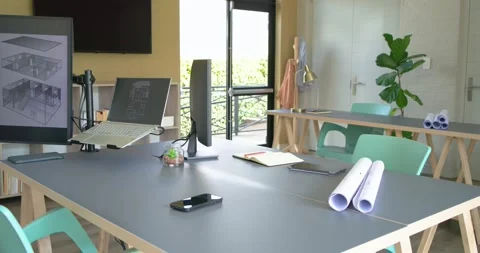 Camera is panning and revealing laptop, notebook and blueprints on work desk to Stock Footage 343366207
