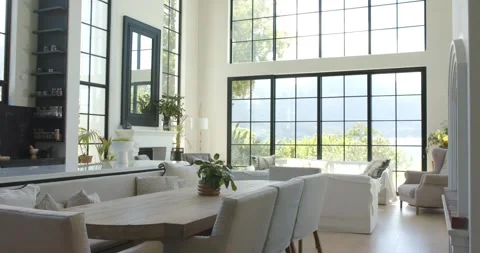 Camera panning and tilting right, revealing wood dining table, bench and tall Vídeos de archivo 336247635